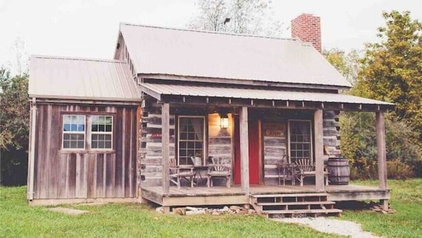 A rustic log cabin with a porch and a chimney. - Audrey's Abode - Restored log cabin, country setting, minutes from Jacksonville
 (Jacksonville)