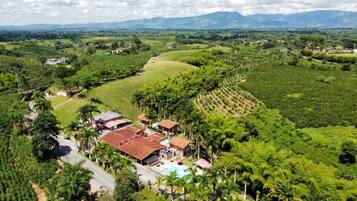 A large estate with multiple buildings, a swimming pool, and lush greenery.