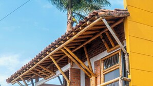 A two-story building with a balcony, a wooden pergola, and a brick facade. - HOTEL PALMAS DE SANTA ELENA  (Quimbaya)