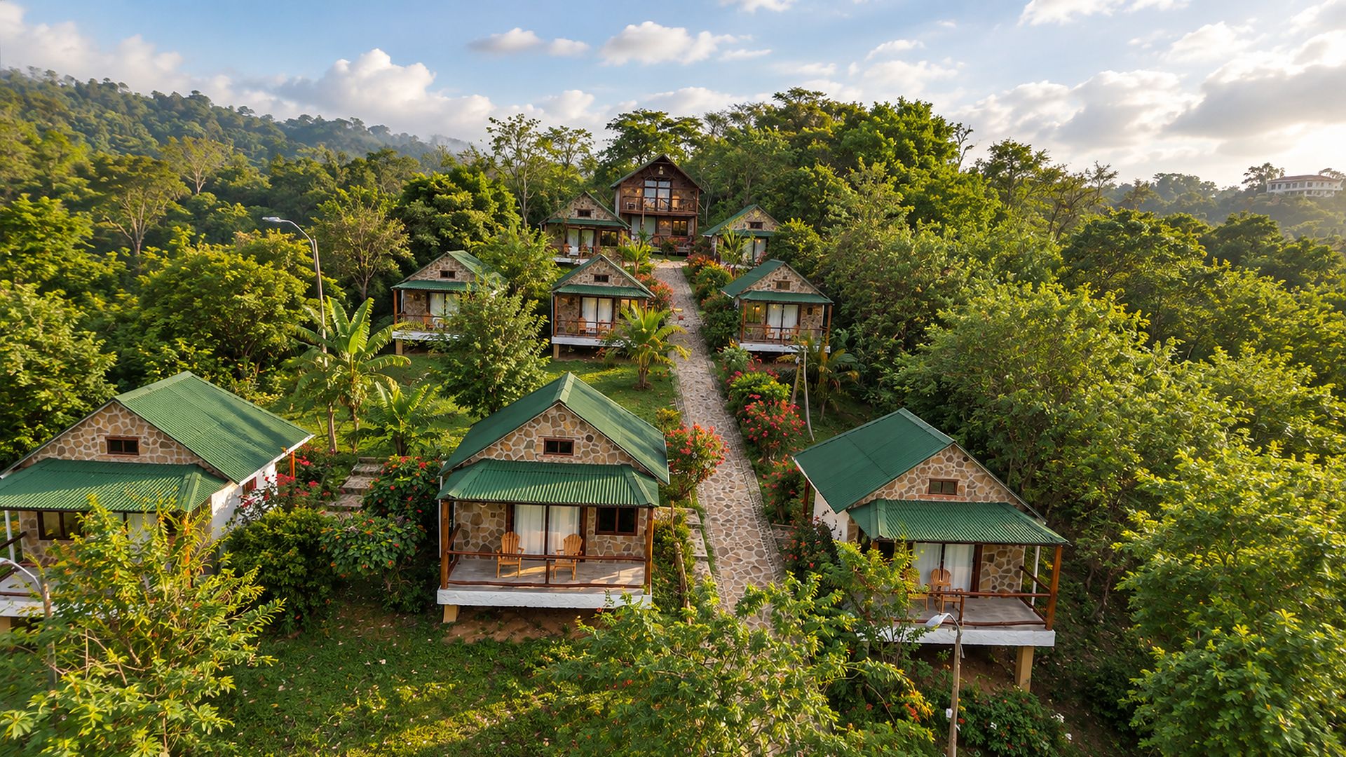 A cluster of stone-roofed cottages with green roofs, surrounded by lush greenery and a clear sky.