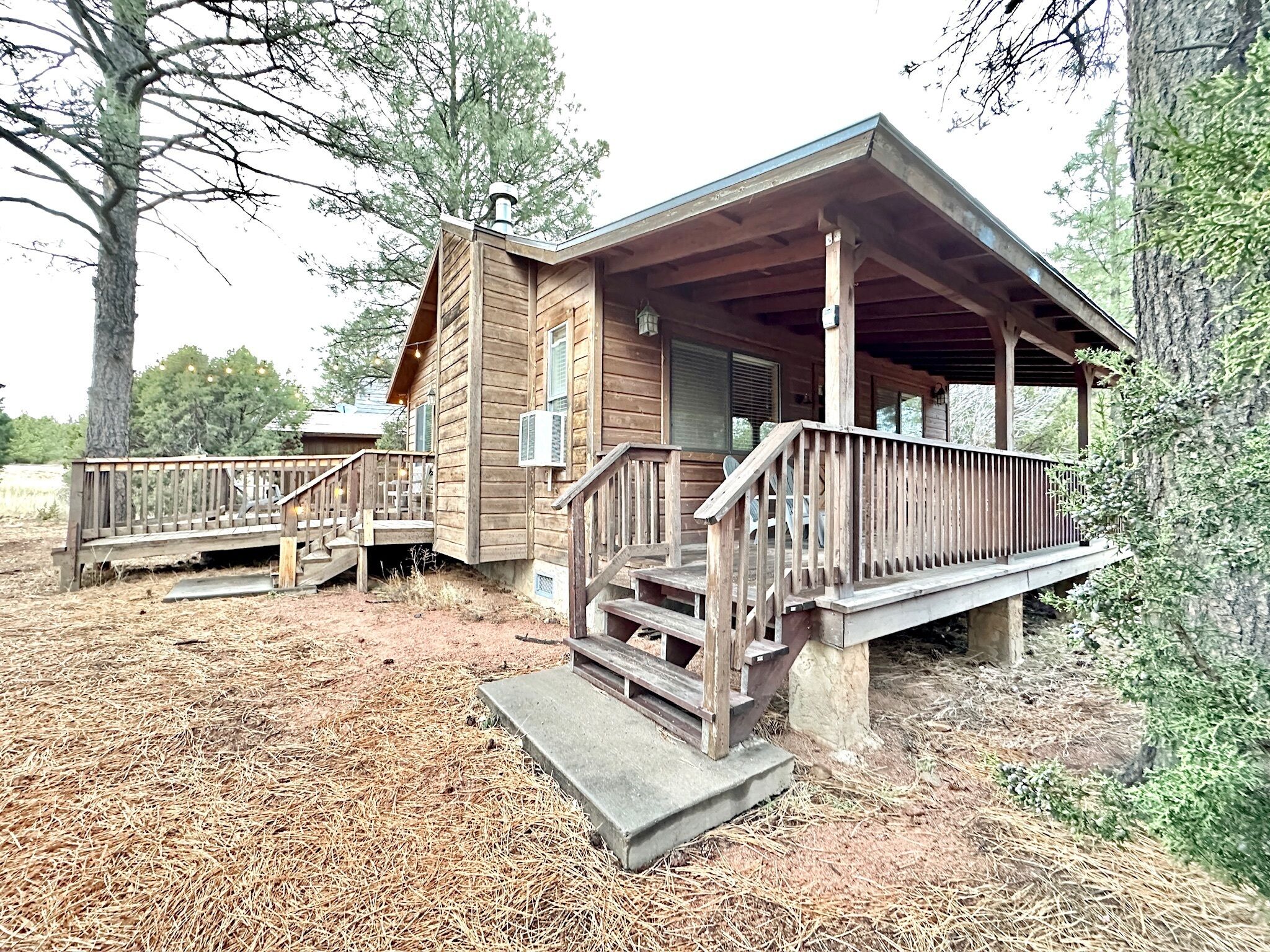 A wooden cabin with a porch and a small staircase leading to the entrance.