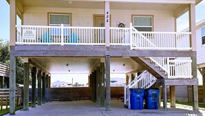 A two-story house with a balcony, a covered porch, and a staircase leading to the upper floor.