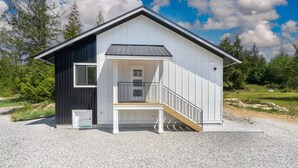 Een modern huis met twee verdiepingen, een balkon, een voordeur en een klein voortuintje.
