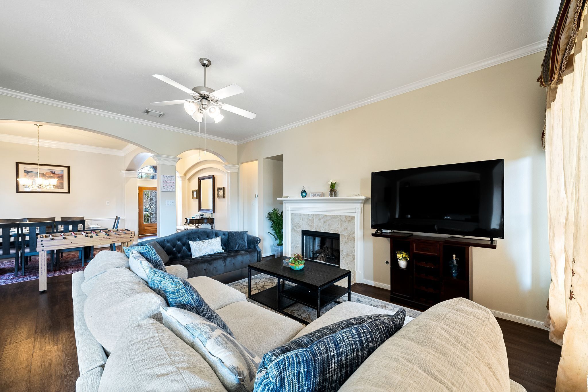 A living room with a sofa, coffee table, fireplace, and TV.