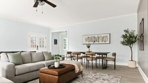 En moderne stue med sofa, sofabord og spiseplads.