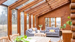 Un intérieur de chalet chaleureux, avec un revêtement en bois, un coin repas et un canapé.