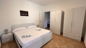 Ein Schlafzimmer mit Bett, Nachttisch, Kleiderschrank und Stadtbild an der Wand.
