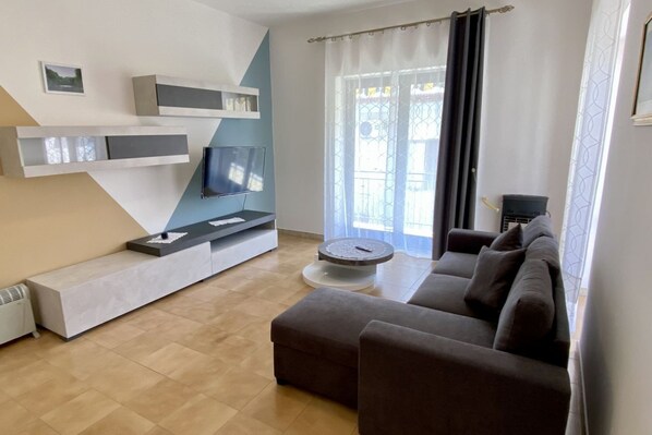 A modern living room with a sofa, a coffee table, and a TV on a built-in shelf.