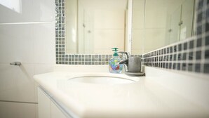 A bathroom with a white sink, a faucet, and a bottle of hand soap. - Mamad Panoramic Red Sea | Chic 3BR Haven (Eilat)