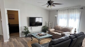 A living room with a sofa, a coffee table, a television, and a ceiling fan. - SEVEN National Parks w/in 2 hrs. Come EXPLORE. Come PLAY. Come RELAX...REPEAT!!! (Kanab)