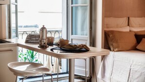 Ein Zimmer mit einem Bett, einem Tisch mit Kaffeemaschine, Tassen und einem Servietttuch.