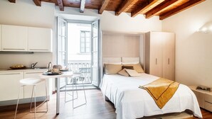 Ein modernes Schlafzimmer mit Bett, Nachttisch und Blick auf den Balkon.