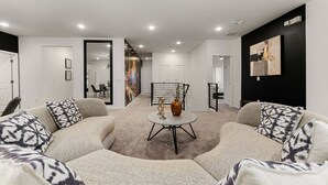 Ein modernes Wohnzimmer mit einer Sofagarnitur, einem Couchtisch und einem Bild an der Wand.