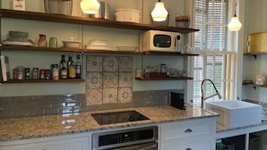 Una cocina moderna con encimeras de granito, electrodomésticos de acero inoxidable e iluminación decorativa.