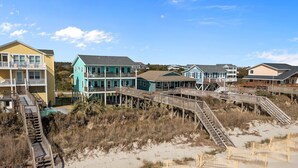 A beachfront property with multiple houses connected by wooden walkways. - "Narwhal Nest" Newly remodeled, 5 bed/3 bath, oceanfront home! (Supply)