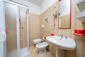 Een douche, een haardroger, een bidet, handdoeken