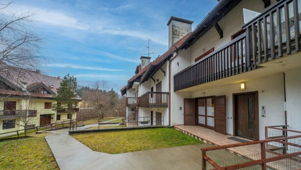 A residential building with a central courtyard, balconies, and a gated entrance.