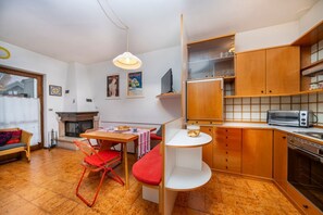 Un espace de vie compact comprenant un coin repas, une cuisine et un coin salon.