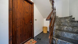 A wooden door, a small rug, and a staircase with marble steps.