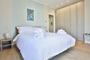 Una camera d'albergo moderna con un letto grande, un comodino, una lampada e un quadro appeso alla parete.