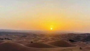 Paisaje desértico con dunas de arena al atardecer.