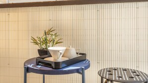 A small table with a tray holding a teapot and a cup, a potted plant, and a chair. - Studio Baldosa - Welkeys (Bandol)
