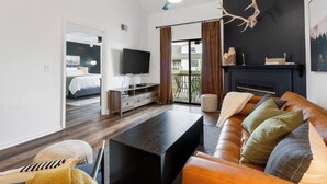 Una sala moderna con un sofá de cuero, una mesa de centro oscura y una chimenea.