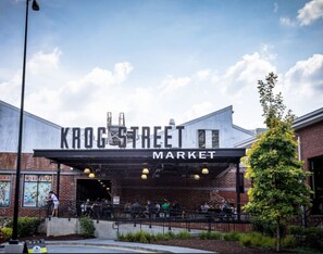 Un bâtiment sur lequel on peut lire l’inscription « KROGSTREET MARKET » et qui dispose d’un espace extérieur abrité avec des sièges.