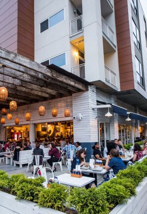 An outdoor dining area with tables and chairs, surrounded by greenery. - Atlanta Beltline Luxury Suite (Atlanta)