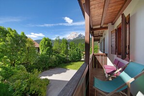 En balkon med udsigt til et bjerg, omgivet af vegetation.
