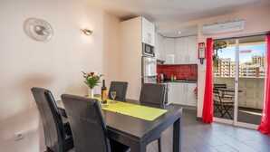 A modern kitchen with white cabinets, a microwave, and a red tiled backsplash. - Apartment 'Carpe Diem' with Balcony, Wi-Fi and Air Conditioning (Portimão)