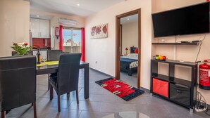 A modern living room with a dining area, a TV, and a fire extinguisher. - Apartment 'Carpe Diem' with Balcony, Wi-Fi and Air Conditioning (Portimão)
