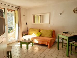 Une pièce comprenant un lit, une table, une chaise, une lampe et une fenêtre.