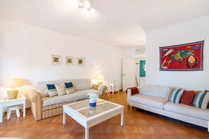 A living room with two sofas, a coffee table, and a wall-mounted painting.