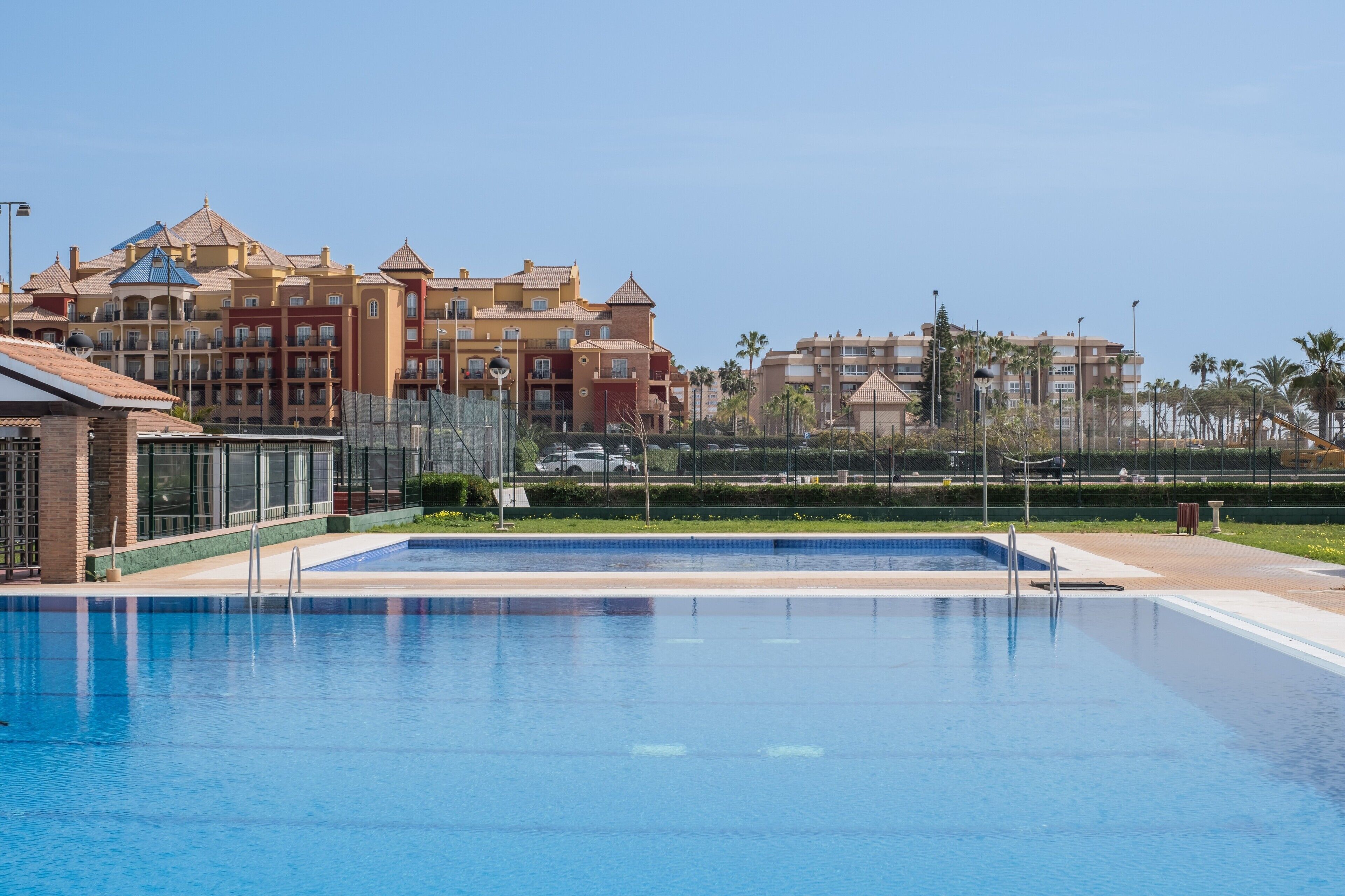 Piscina com vista clara para edifícios de hotel ao fundo.