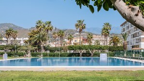 A swimming pool with palm trees and buildings in the background. - Apartment 'Experiencia Marina A107' with Sea View, Wi-Fi and Air Conditioning (Torrox)