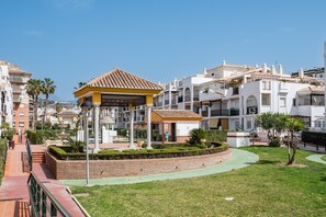 A residential area with a gazebo, a fountain, and a well-maintained garden.