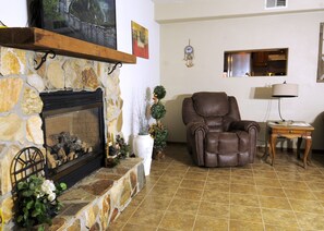 TV connectée, cheminée, livres, chaîne hi-fi