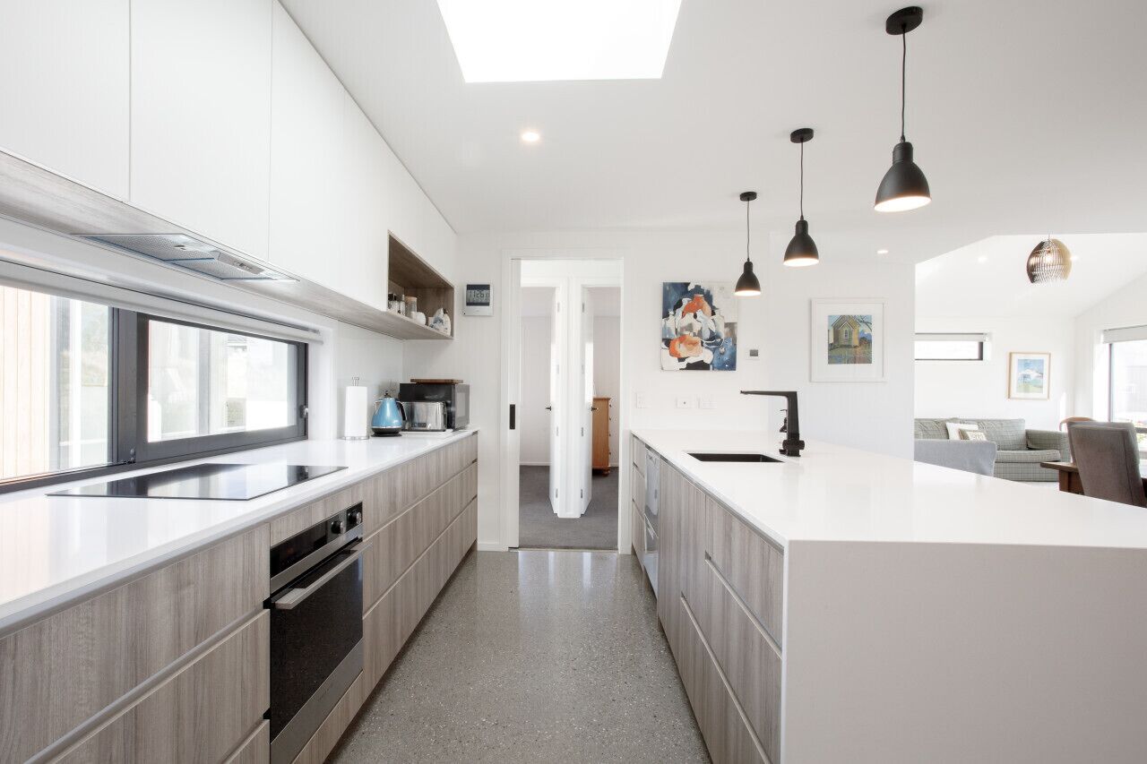 A modern kitchen with a central island, built-in appliances, and pendant lighting.