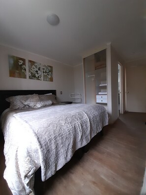 A bedroom with a bed, a wardrobe, and a door leading to another room. - Patagonia Norte Pto.Varas Homestay  (Puerto Varas)