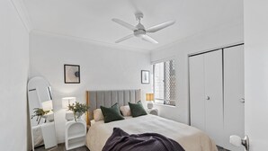 A bedroom with a bed, a ceiling fan, a window with blinds, a door, and a mirror. - Leafy central stylish apartment in great location. (South Perth)