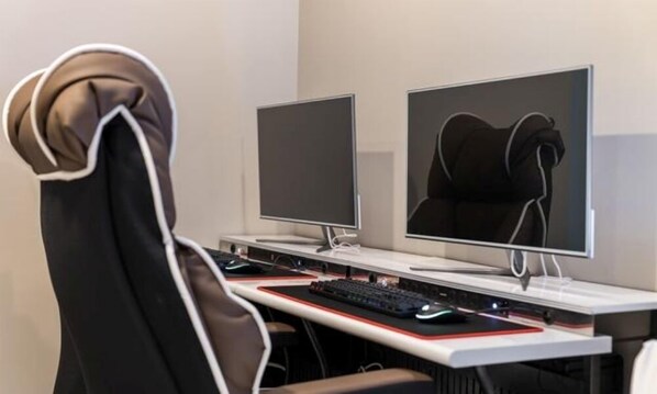 A modern gaming setup with two monitors, a keyboard, and a mouse on a desk.