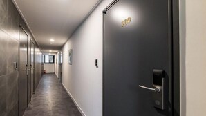 Un couloir moderne avec une porte portant l’inscription « 2009 » et un système de verrouillage numérique.