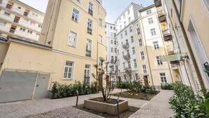 A courtyard with a central planter, surrounded by multi-story buildings with balconies and windows. - Piękna Chic Apartment (Warszawa)