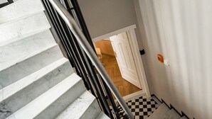 A staircase with marble steps and a black metal railing. - Piękna Chic Apartment (Warszawa)