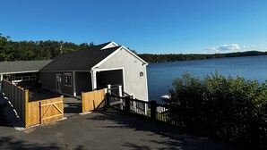 En fastighet vid vattnet med en brygga, ett garage och utsikt över sjön.