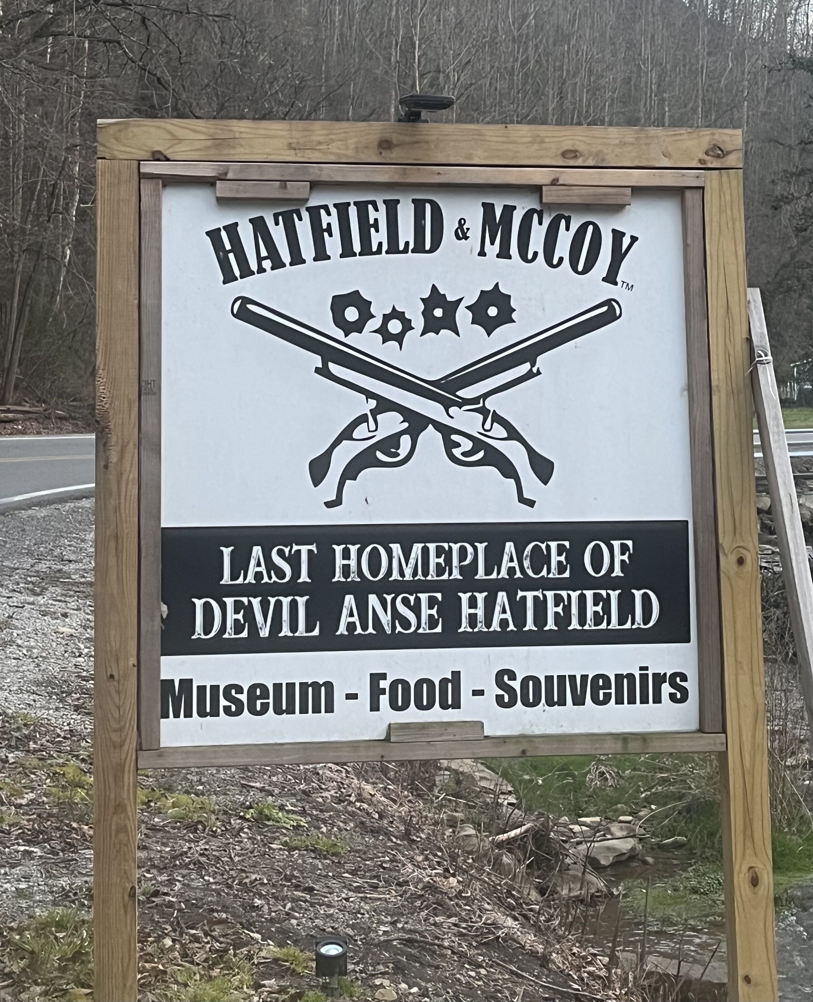 A signboard for Hatfield & McCoy, mentioning it as the last home of Devil Anse Hatfield, with sections for a museum, food, and souvenirs.