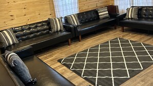 Una sala de estar moderna con un sofá modular, un tapete estampado y paredes de madera.