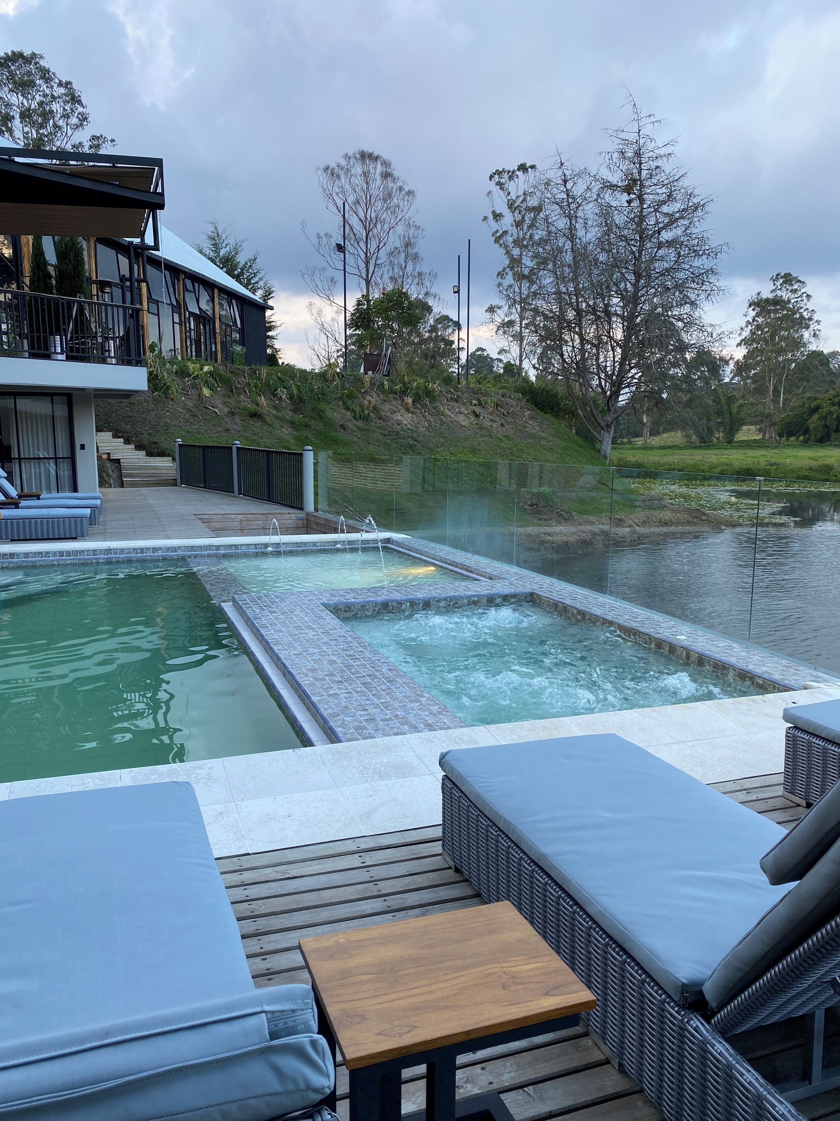 A pool area with lounge chairs and a wooden deck.