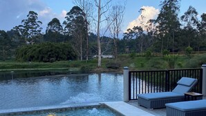 A swimming pool with a hot tub, lounge chairs, and a view of the surrounding landscape. - Monarch Campestre (El Carmen de Viboral)